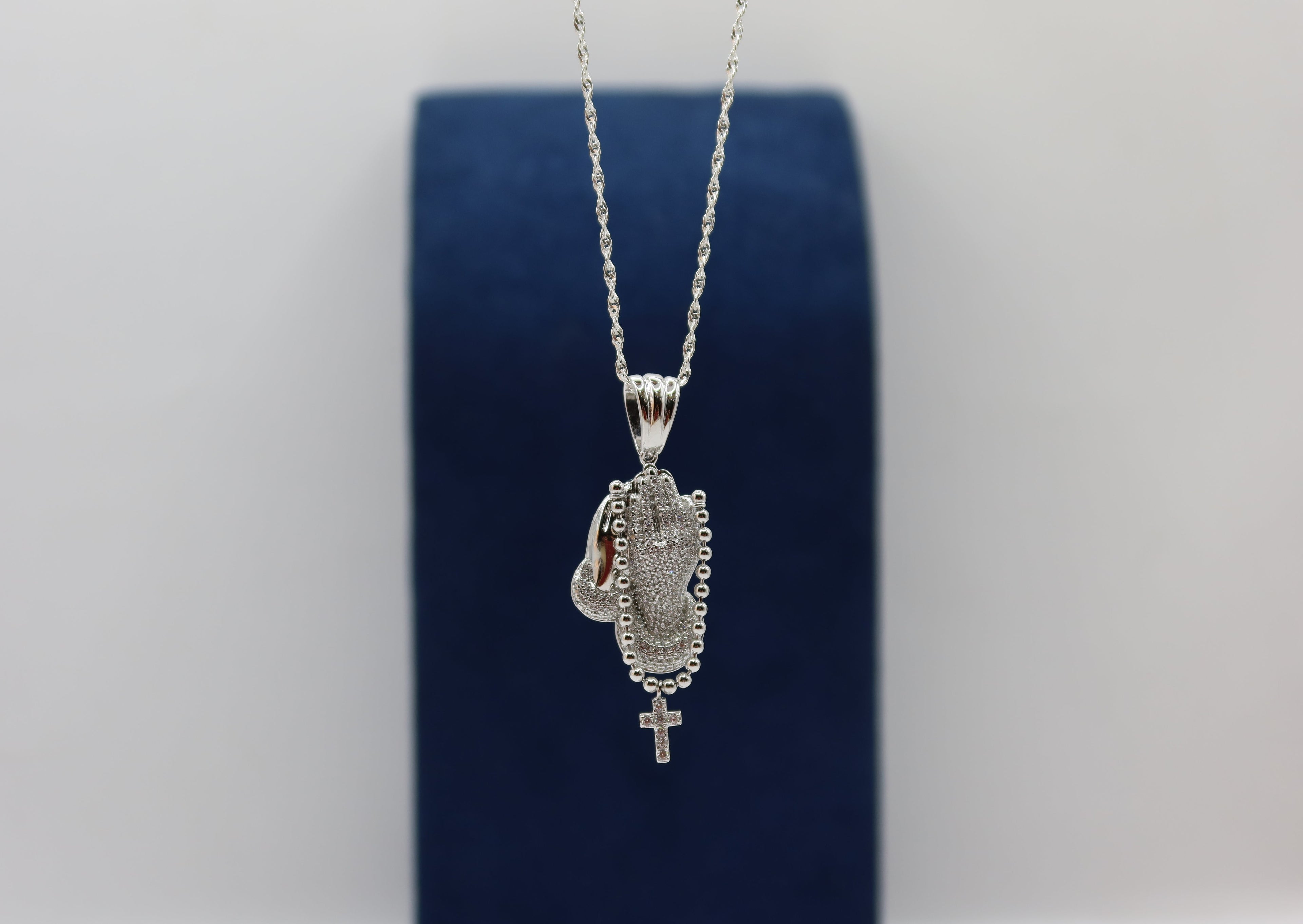 Dije manos con rosario